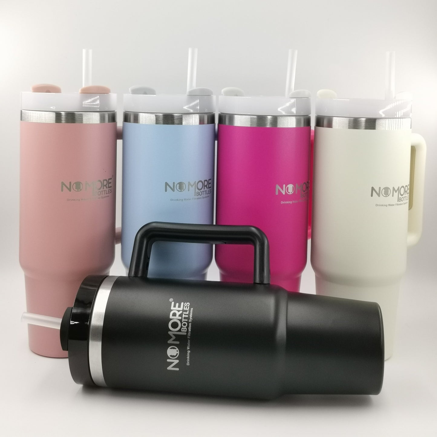 Set of colorful tumblers with straws and a black bottle in front.